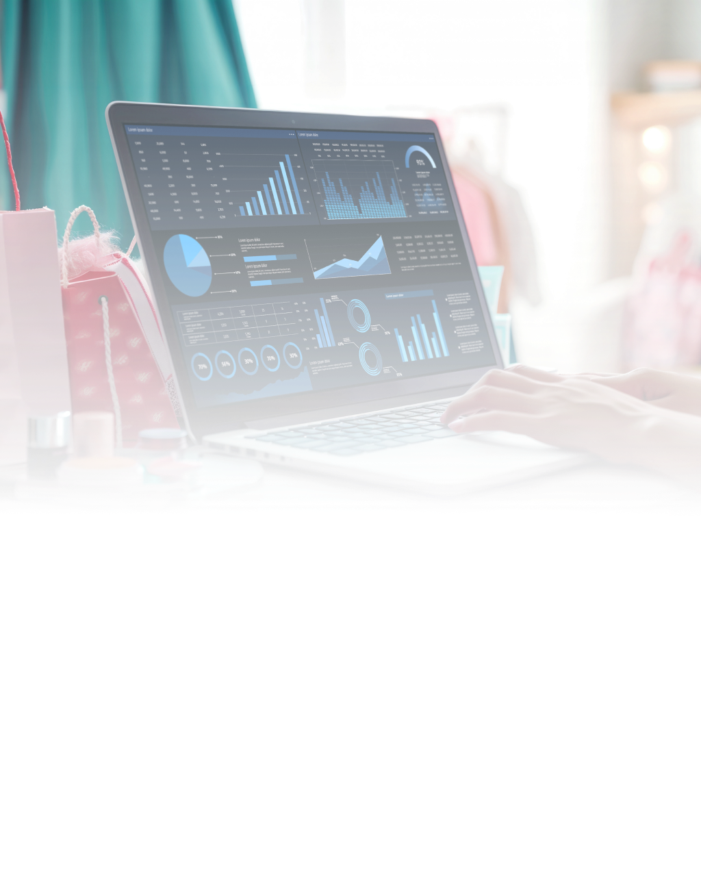 A person looking at graphs and data on a laptop screen and sitting at the desk