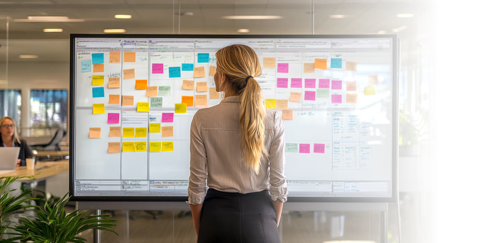 woman in front of a whiteboard with sticky notes