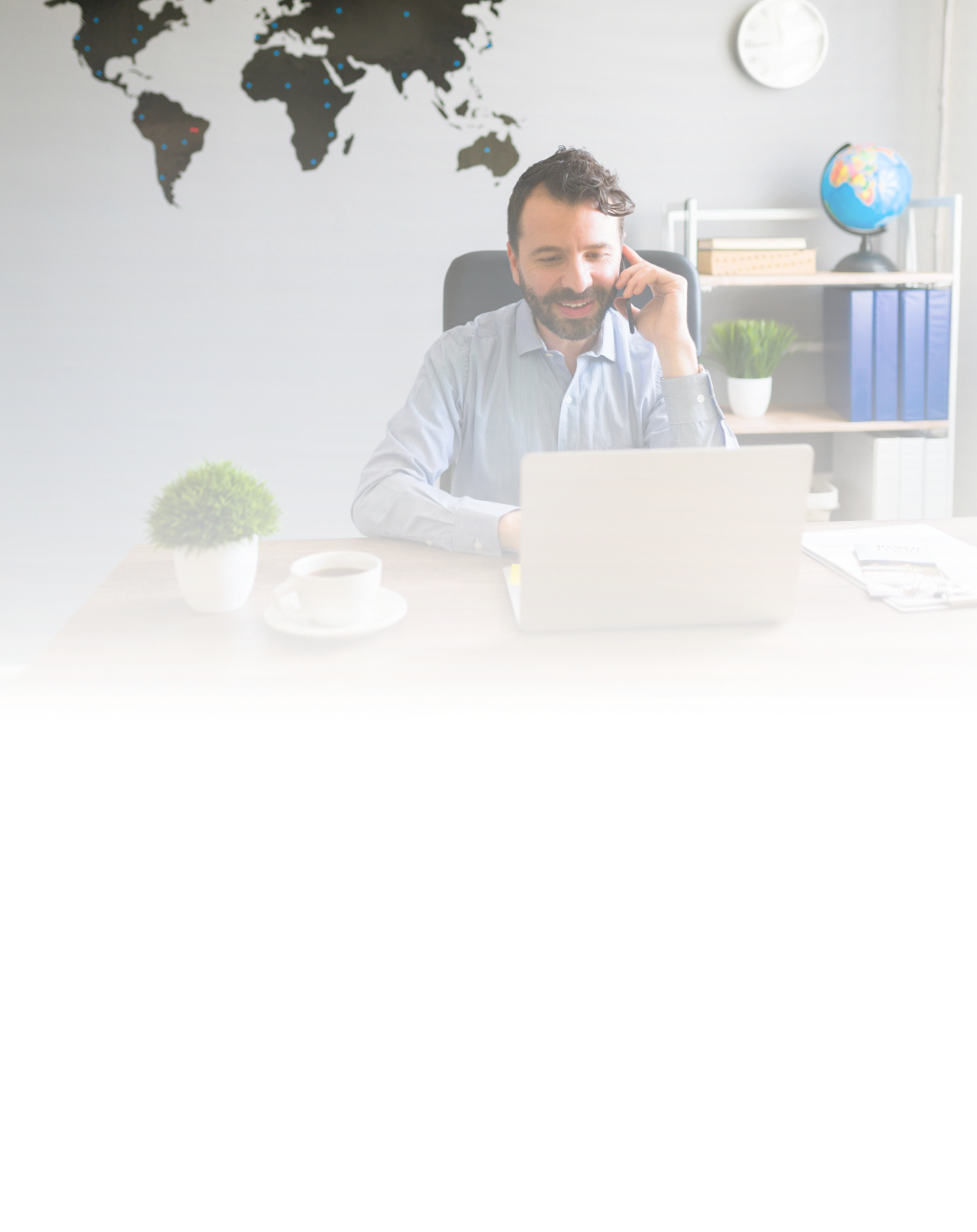 a man talking on the phone and working on a computer