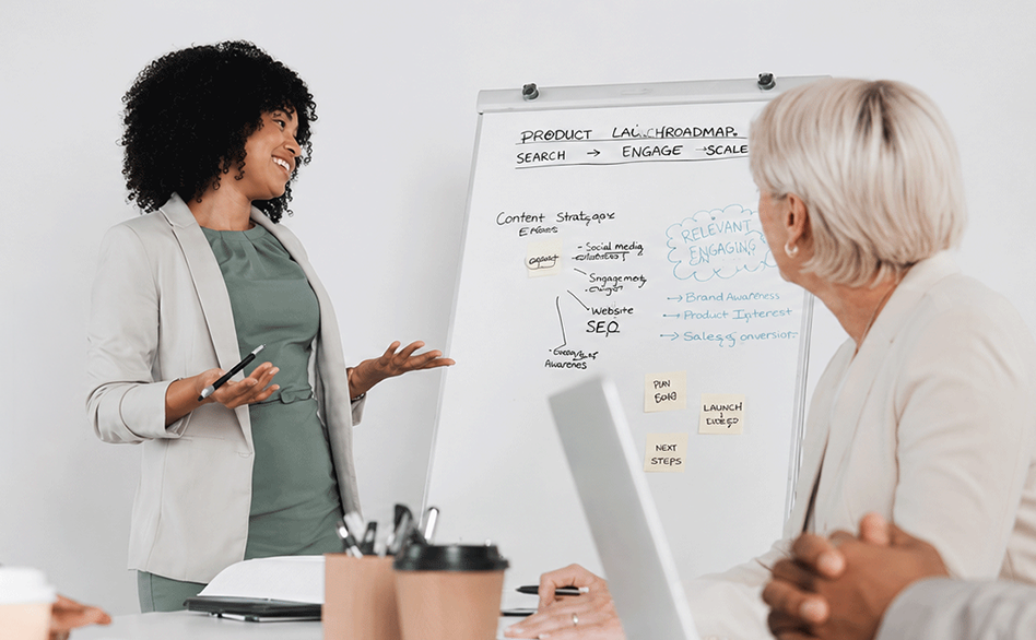 A multicultural team of technology specialists collaborating on ideas and strategy during an interactive whiteboard workshop