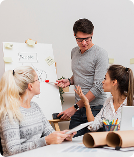 A man presenting ideas on a whiteboard during a collaborative team workshop.
