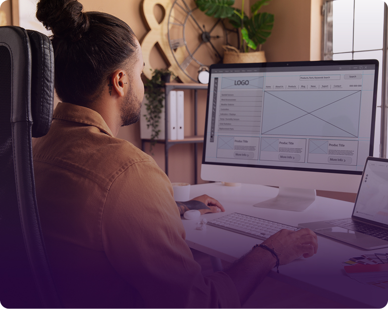 Man working at a computer reviewing wireframes for web and mobile UX/UI audits