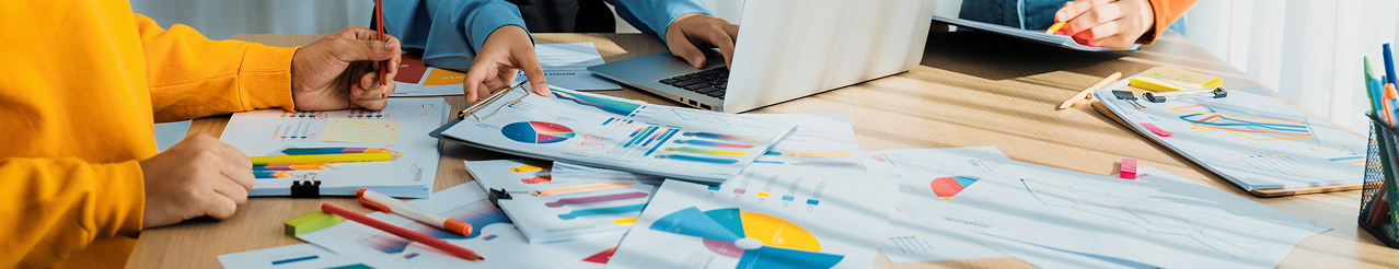 People reviewing charts and data printouts on a desk