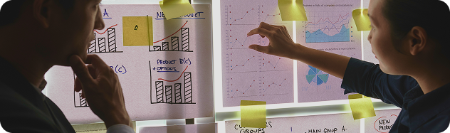 Two IT consultants analyzing wireframes and sticky notes on a glass planning board during an initial scoping assessment