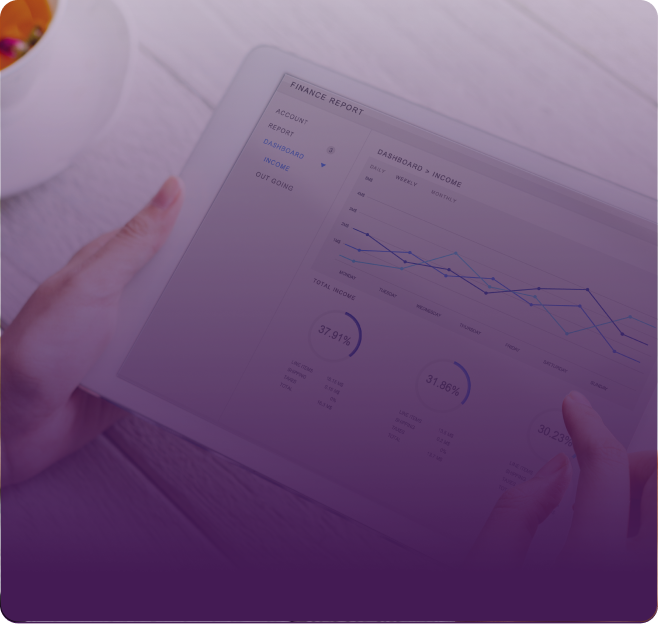 A hand holding a tablet displaying charts and data