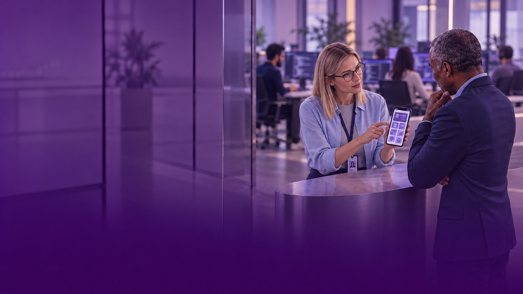 Blonde developer demonstrating banking app with colleagues working behind her